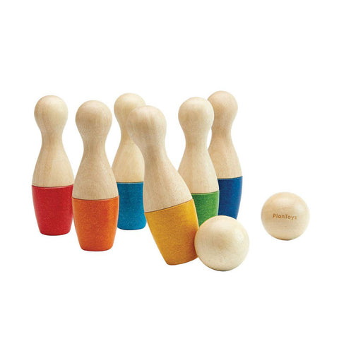 Set of wooden bowling pins with colorful bases and a ball 